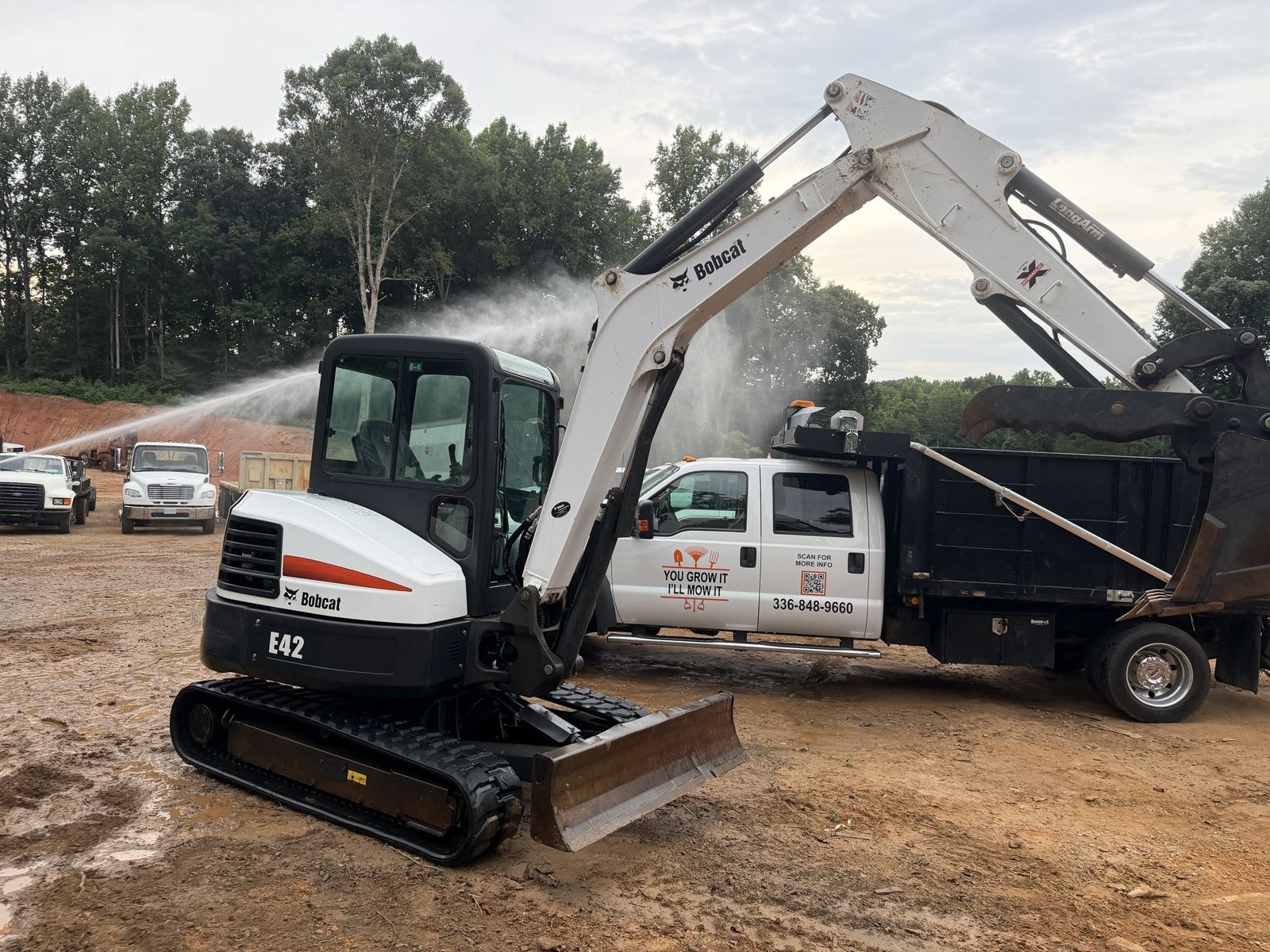 Pressure washing an excavator on a construction site