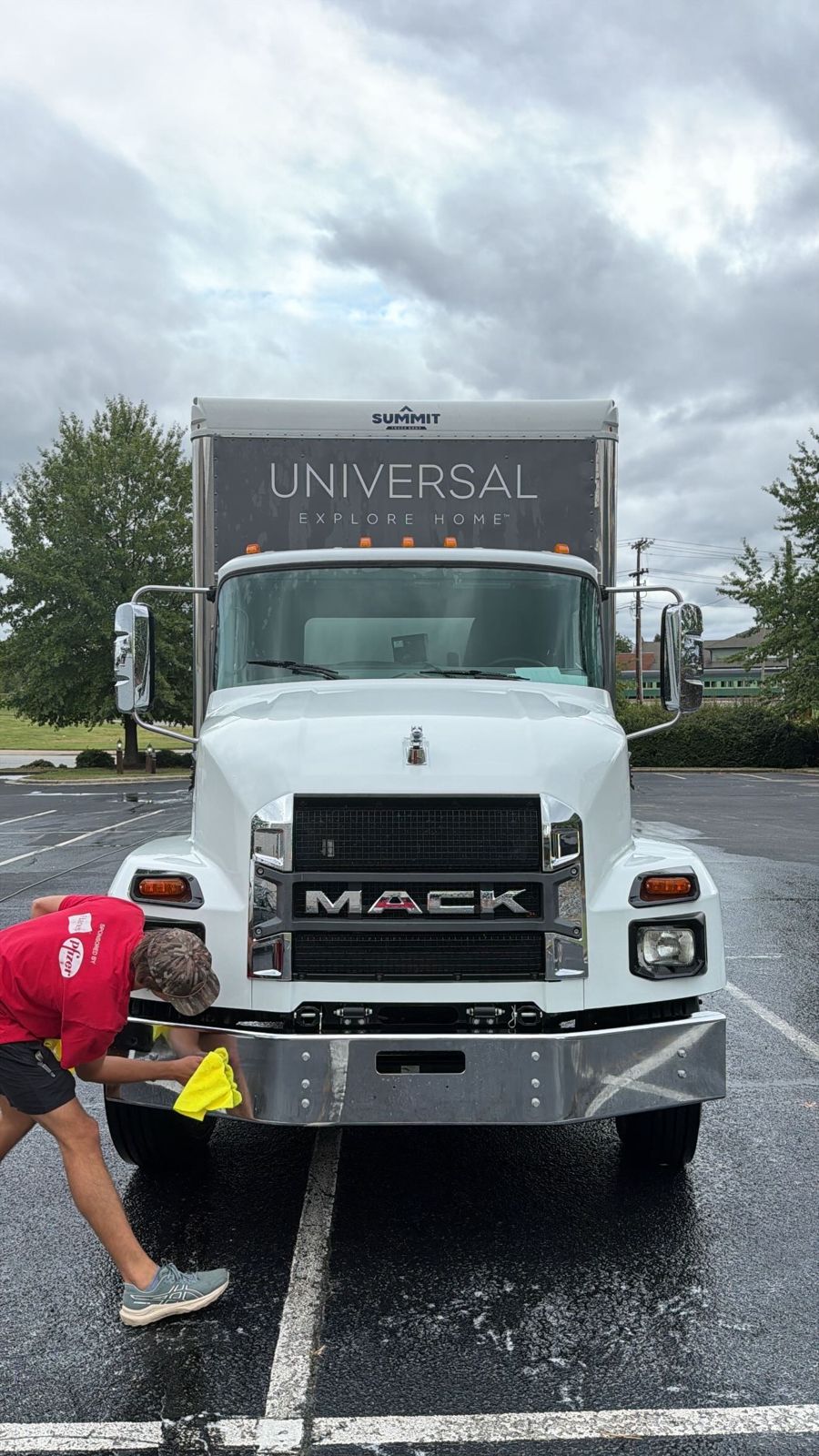 A KDR crew member hand-drying the chrome bumper of a freshly washed box truck