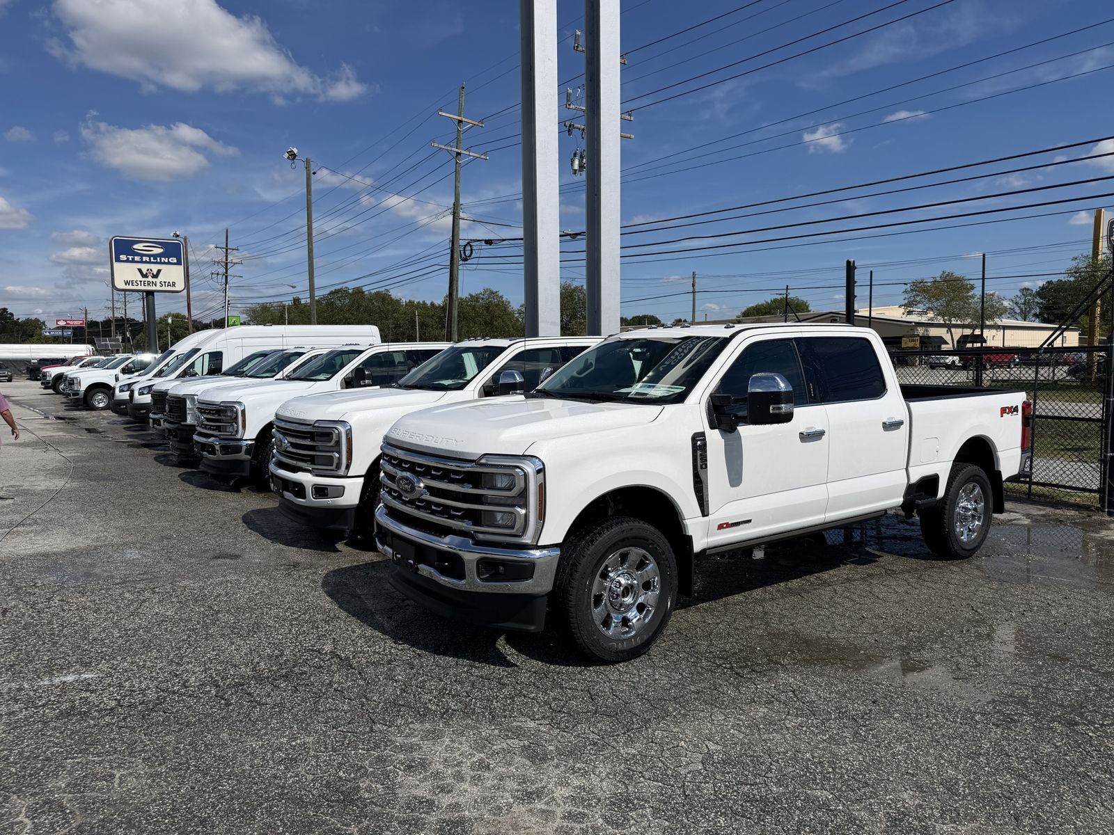 A row of freshly washed white work trucks